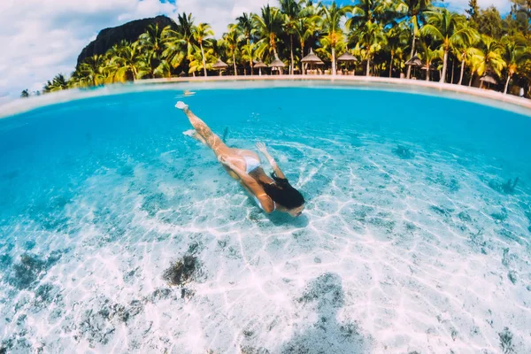 Mujer atractiva joven nadando bajo el agua en azul transparente o — Foto de Stock