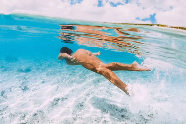 Mujer atractiva joven nadando bajo el agua en azul transparente o — Foto de Stock