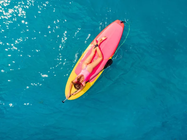 Attraktive Frau auf Stand Up Paddle Board auf einem ruhigen blauen Ozean. — Stockfoto