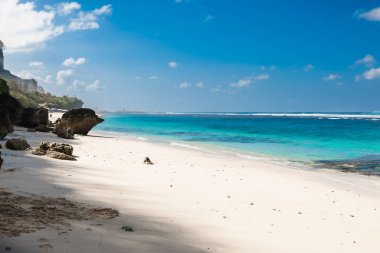 Beyaz kumlu, mavi okyanuslu ve berrak gökyüzü olan tropik bir sahil.