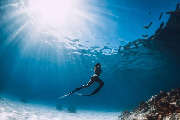 샌디 해 위에서 지느러미를 가진 매력적 인 여자 자유인 잠수부가 활공 한다. 프레 — 스톡 사진