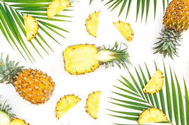 Dilimlenmiş ananas deseni ve beyaz sırtüstü palmiye yaprakları.