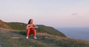 Sportif formda kız gün batımında ya da gün doğumunda açık havada aerobik egzersizler yapıyor. Spor, eğitim ve sağlık konsepti.