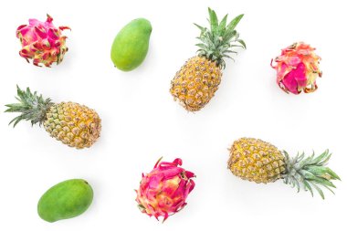 Beyaz arka planda ananas, mango ve ejderha meyveli tropik meyve deseni. Düz yatış, üst görünüm