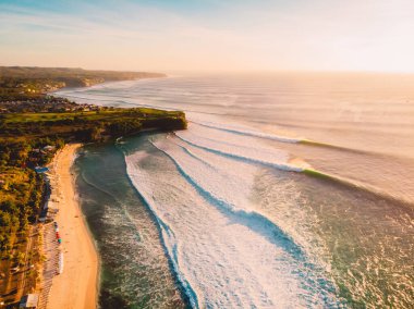 Gün batımında dalgalı okyanus manzarası ve Bali 'de tropikal plaj