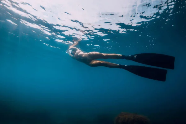 スポーティ女性フリーダイバーとともにフィングライド水中で青い海 — ストック写真