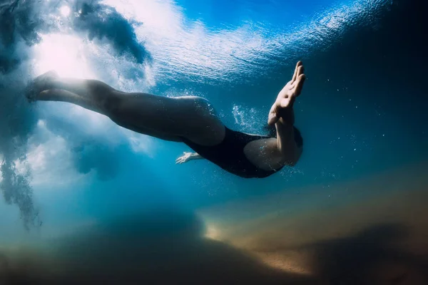 海の波の下でサーフボードなしで女性ダイビング 波と砂の底の下に潜る水中アヒル — ストック写真