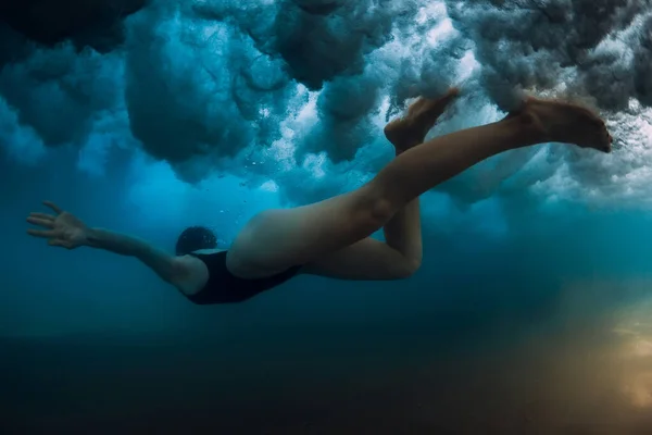 海の波の下でサーフボードなしで女性ダイビング 波と砂の底の下に潜る水中アヒル — ストック写真