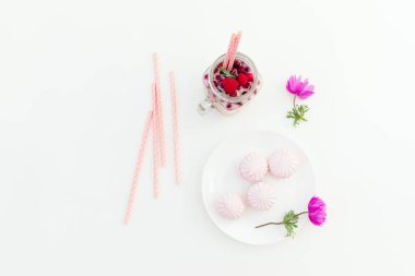 Beyaz arka planda çilekli smoothie, marshmallow ve anemone çiçekleri. Düz yatıyordu.