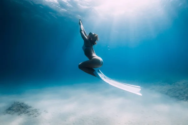 魅力的な女性フリーダイバーグライドとポーズ上砂の底とともにホワイトフィン — ストック写真