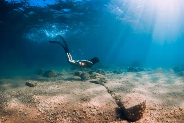 비키니를 여인은 바다에서 광선을 받으며 속에서 지느러미를 잠수하는 — 스톡 사진