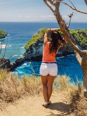 Endonezya 'nın Nusa Penida adasındaki Atuh plajında poz veren genç bir kadın.