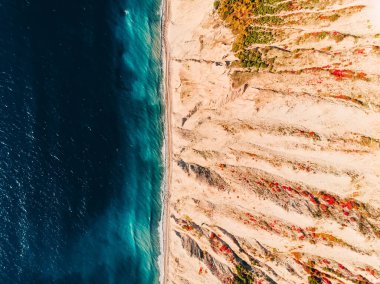 Uçurum ve denizin olduğu kayalık kıyı şeridinin havadan görüntüsü. Üst görünüm