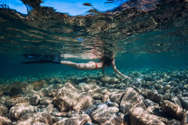 ビキニ姿のフリーディバースリム女性は青い海と太陽の光で滑ります 海の中で水中フィンとフリーダイビング — ストック写真