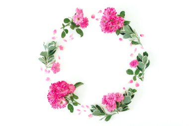 Pembe güllerden yapılmış yuvarlak çerçeve ve beyaz arka planda yapraklar. Düz yatış, Üst Görünüm