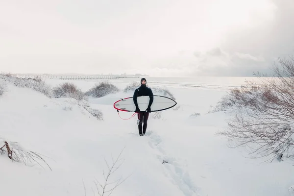 보드가 겨울과 파도타기 잠수복을 파도타기 선수가 눈덮인 — 스톡 사진