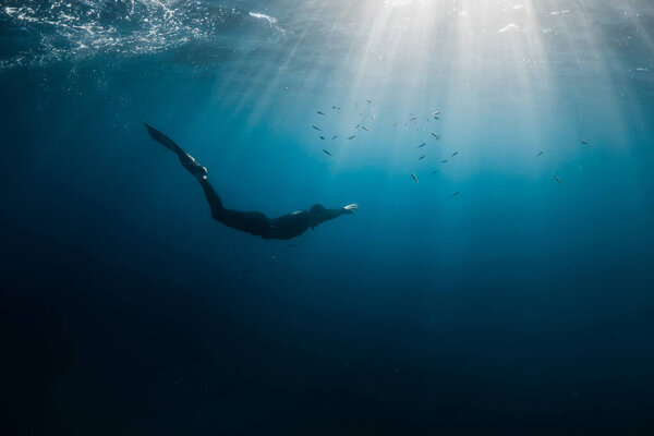 September 10, 2020. Anapa, Russia. Professional freediver in wetsuit with mono fin underwater in transparent sea. Freediving in Black sea