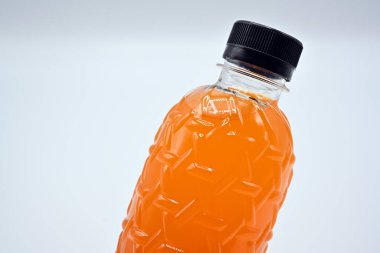 PET plastik şişeler (polietilen tereftalat) beyaz arka planda taze portakal suyu ile siyah kapak