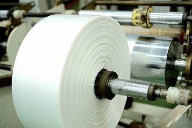 Plastik film rulo şeklinde toplanır. Plastik film yapma makinesinin son aşaması plastik torbalar üretmek..