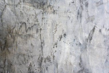 Beton duvar sıvanmış ve cilalanmış. Çatı katı koyu gri ve çatlaklarla kaplı..