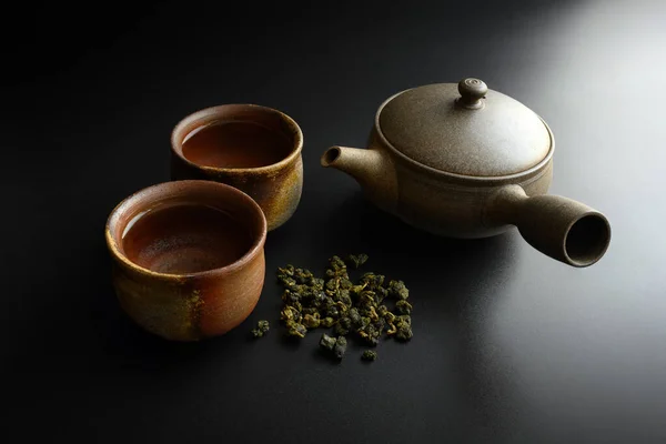 Çaydanlıklar Iki Fincan Çay Yaprakları Üst Taraftaki Siyah Arkaplanda — Stok fotoğraf