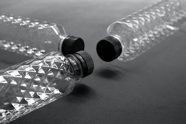 Transparent and empty PET plastic water bottles Was arranged some black backgrounds, the crystal pattern of the glitter bottle In the concept of recycling for the environment