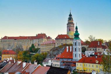 Cesky Krumlov, Çek Cumhuriyeti Sonbaharda, sabah ışığı bu şehri güzelleştirir. Kırmızı evin çatısında sarı yapraklar ve eski kasabanın nehri var.