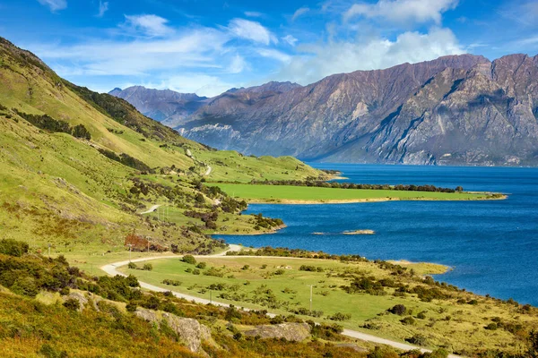 山の景色と湖Hawea 夏には ニュージーランドのオタゴの首に美しい雲のある緑の草と青い空があります — ストック写真