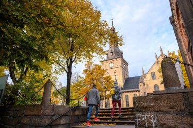 Oslo Katedrali 'ne giden merdivenleri çıkan iki kişi var. Oslo, Norveç' in merkezinde yer alıyor. Sonbaharda yapraklar sarıya ve turuncuya döner..