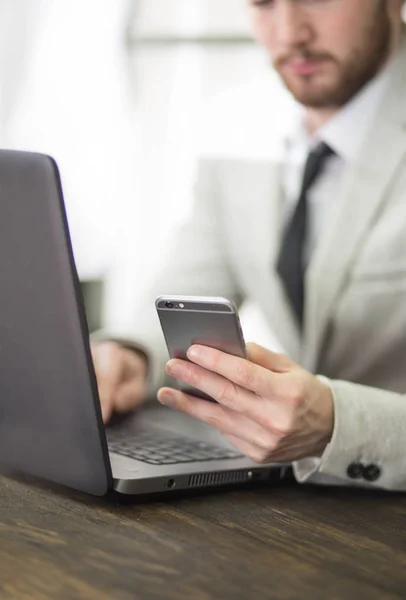 Mondo degli uffici, freno a tempo. Uomo d'affari che lavora al tavolo di legno con un nuovo progetto aziendale. Uomo toccando schermo moderno telefono cellulare. Mockup orizzontale. Flange, effetto film — Foto Stock