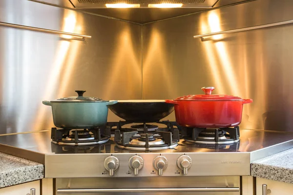 Dapur yang elegan untuk memasak lokakarya di hotel memiliki peralatan mewah dan panci closeup di atas kompor gas yang memiliki api . — Stok Foto
