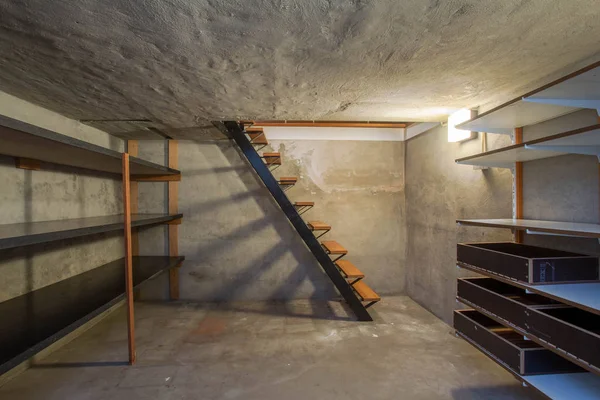 빛도 거의 없고 나무 계단도 없는 버려진 오래 된 산업 건물의 텅 빈 지하실 — 스톡 사진