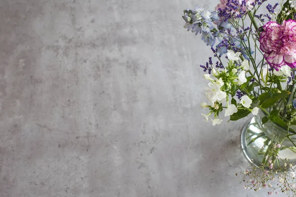 Güzel buket bahar pembe çiçekler Grey tablo üstten görünüm çimento. vazo ile