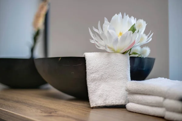 beauty salon table close-up with flower decoration in a spa room and white towels