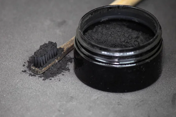 Charcoal on a toothbrush to whiten teeth — Stock Photo, Image