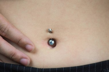 ayrıntılı bir göbek piercing takan genç bir kadının göbek