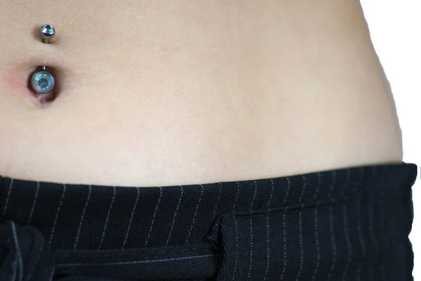 Detalj av buken av en ung kvinna, som bär en navelpiercing — Stockfoto