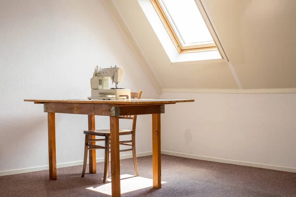 Naaimachine op tafel in een atelier studio, werkplek of hobby kamer — Stockfoto