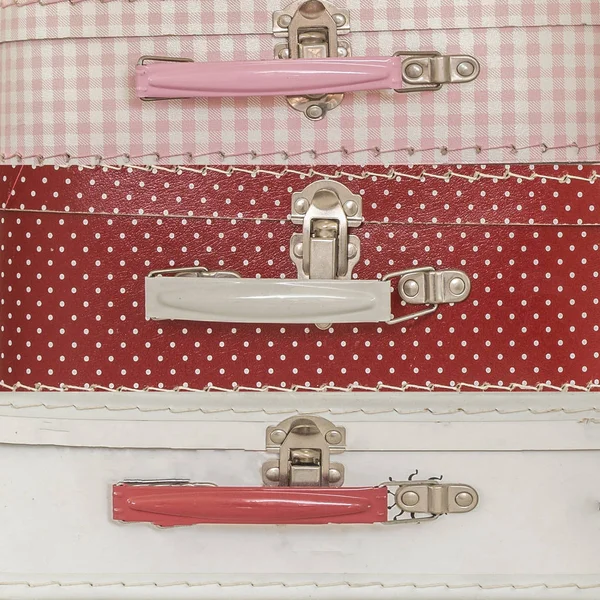 Close up image of pink suitcases with polka dots over pink background texture — Stock Photo, Image
