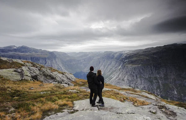 Couple traveling, A couple watching the great view of snow mountains and glaciers in Norway on a cloudy day