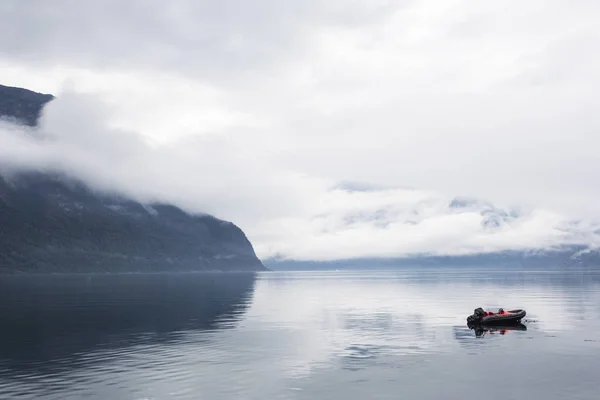 Sedikit perahu di danau berkabut tenang dengan gunung-gunung di latar belakang — Stok Foto