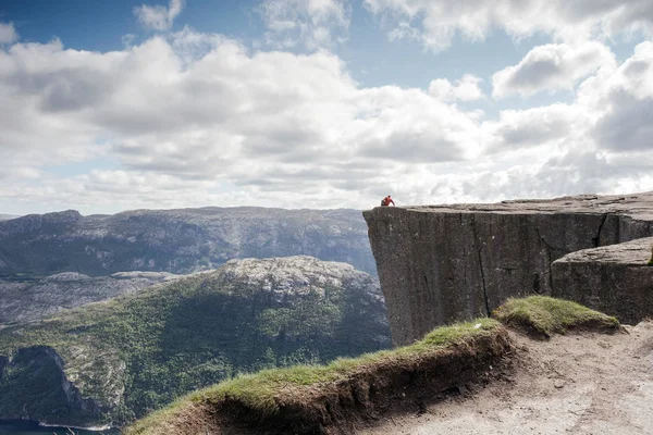 남자 Preikestolen, 아름 다운 노르웨이 산악 풍경에 상자 모양의 대 바위에 앉아 — 스톡 사진