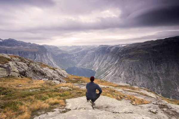 Wandelaar is permanent op een bergtop en waakt over een rustig meertje, mooi moment wonder van de natuur. Wandelaar silhouet kijken. Persoon permanent — Stockfoto