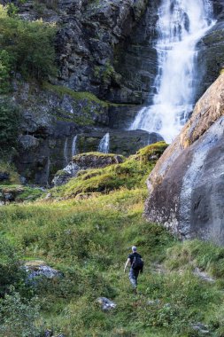 Şelale Park güzel sonbahar doğa manzara bakarak sırt çantası ile hiking uzun yürüyüşe çıkan kimse. Erkek yetişkin geri açık duran portresi.