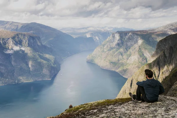 Мужской турист отдыхает на вершине горы, наслаждаясь видом — стоковое фото