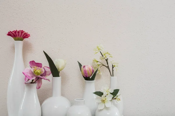 Fleurs roses différentes dans des vases sur fond blanc — Photo