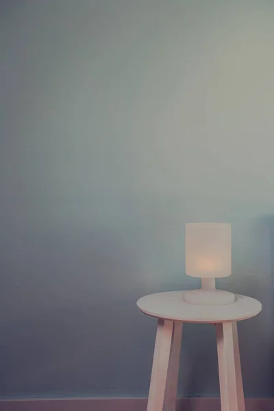 Φωτιστικό νύχτας σε ξύλινο τραπέζι με μπλε τοίχο για κείμενο χώρο. Εφέ Βίντατζ στυλ εικόνα. Ελάχιστη έννοια. υφή φόντου — Φωτογραφία Αρχείου