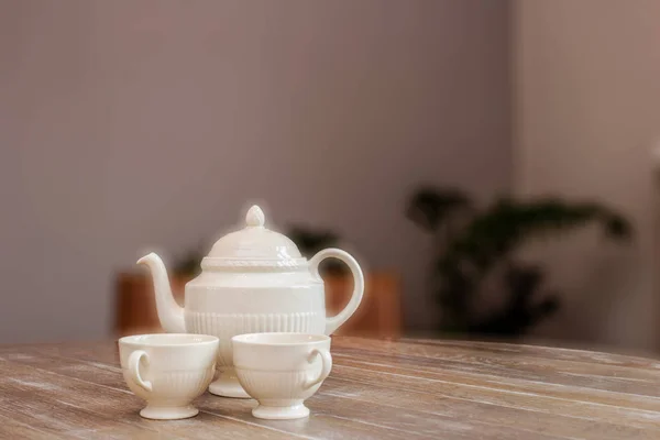 Panela de chá e xícaras na mesa de madeira, ainda vida em uma casa design vintage bonito e acolhedor, espaço para texto — Fotografia de Stock