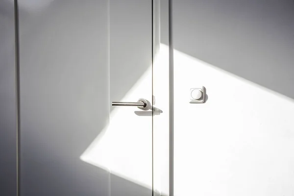 Close-up white door with sunlight. Chrome door ,The light switch on the wall modern design empty and clean — Stock Photo, Image