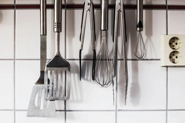 Кухонная посуда висит на стене на кухне — стоковое фото